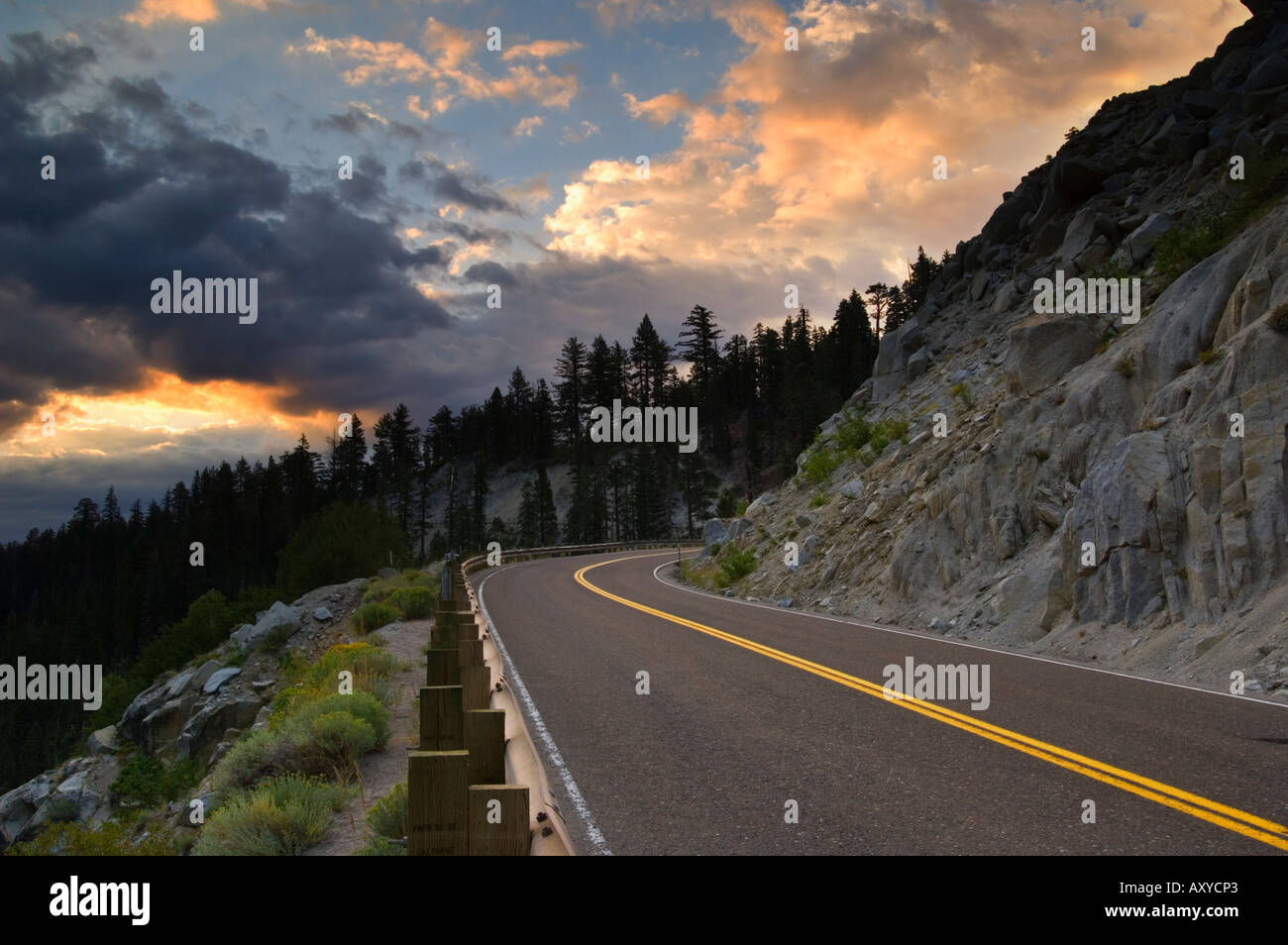 Sunrise luce sulle nuvole temporalesche al di sopra della curva di strada di montagna Emerald Bay State Park South Lake Tahoe regione California Foto Stock