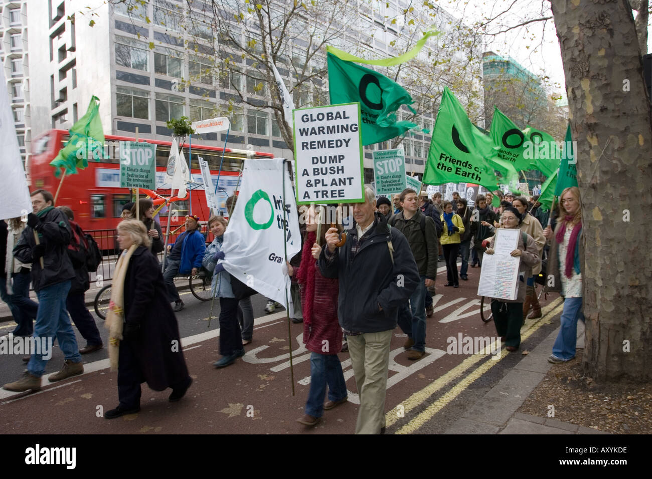 Gli attivisti che trasportano banner Global Warming Remedy Dump cespuglio pianta un albero sul Cambiamento Climatico marzo il 3 dicembre a Londra REGNO UNITO Foto Stock
