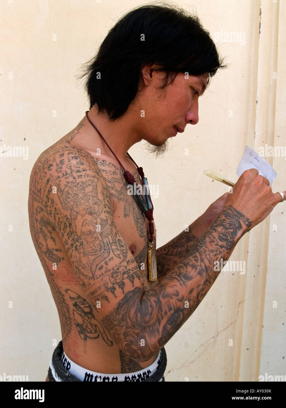 In posa con tatuaggi al Wat Phra Bang Tattoo Festival in Thailandia Foto Stock
