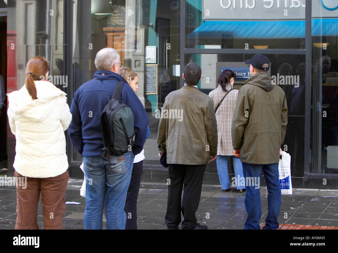 La gente in coda per utilizzare una banca ATM macchina in Belfast City Centre Foto Stock