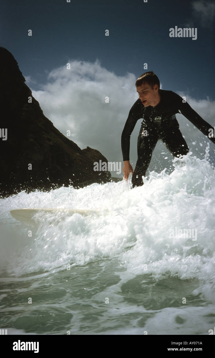 Navigare cavalcando le onde sulla tavola da surf a porthtowan Cornwall Regno Unito Foto Stock