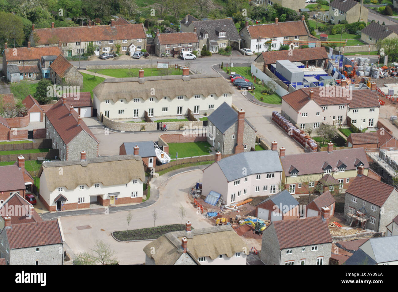 Vista aerea del moderno sviluppo di alloggiamento in uno stile tradizionale a fianco di borgo vecchio alloggiamento in un villaggio rurale Somerset Foto Stock