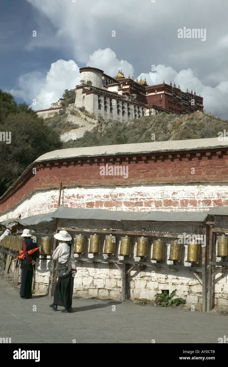 Pellegrini spin ruote della preghiera al di fuori del palazzo del Potala, Lhasa, la regione autonoma del Tibet, Cina. Settembre 2006. Foto Stock