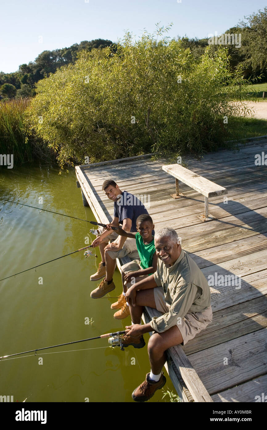 Ritratto di un uomo di pesca con suo figlio e amico sul molo Foto Stock