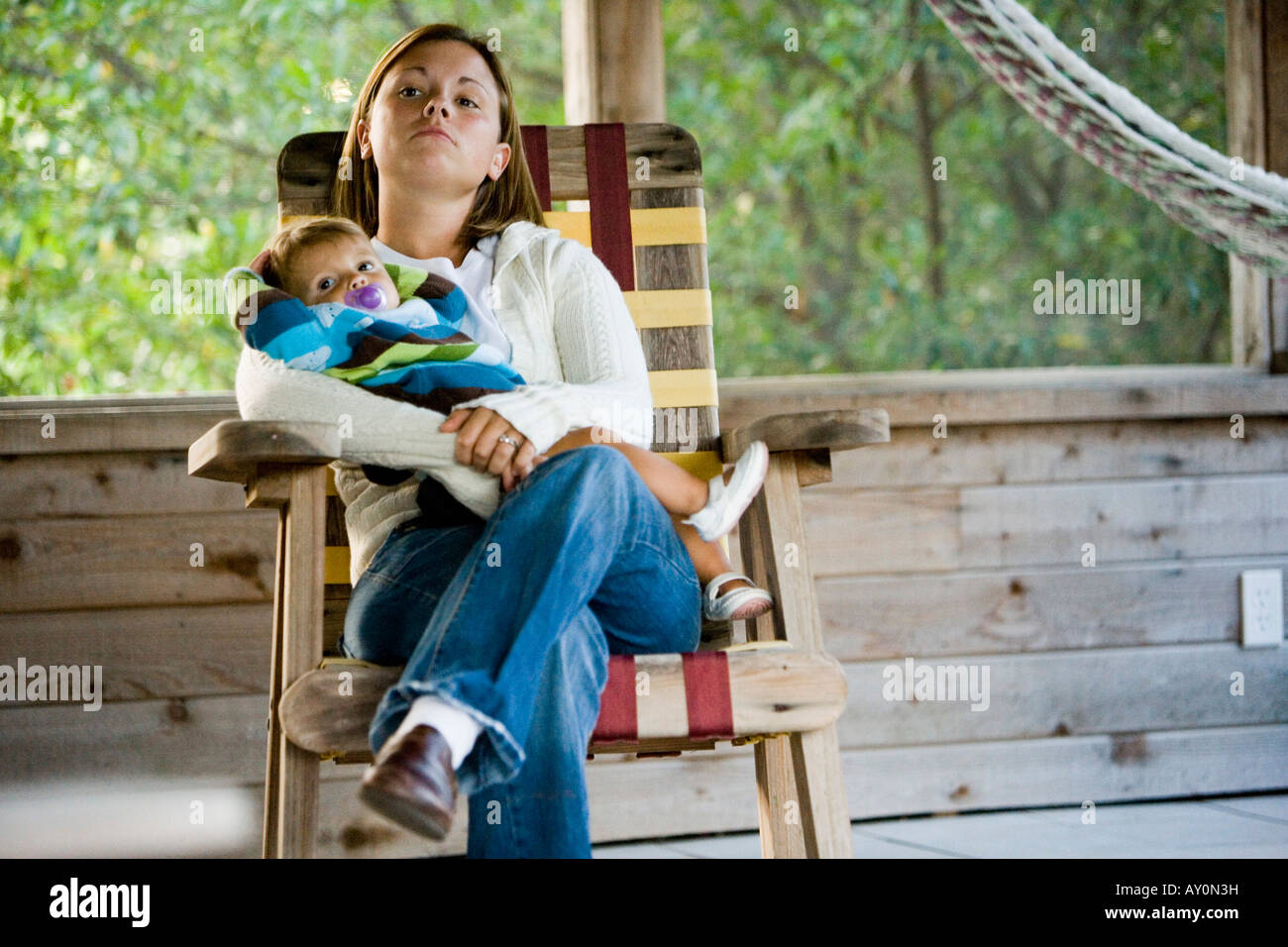 Madre mentre tiene il suo figlio sulla poltrona in una casa Foto Stock