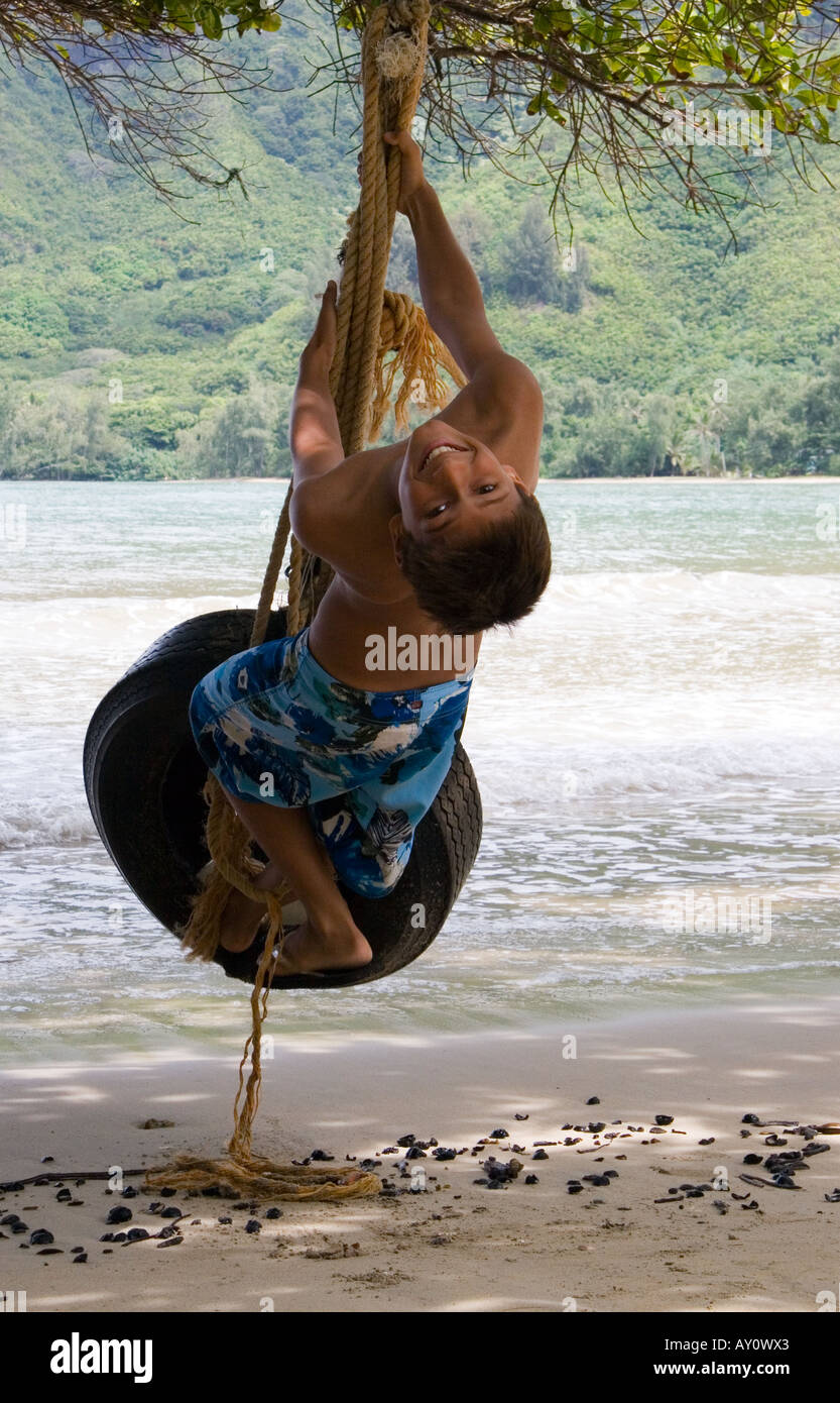Ragazzo su un pneumatico (pneumatico) swing in Oahu, Hawaii Foto Stock