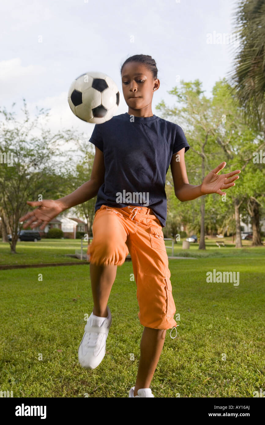 Ragazza bouncing soccer ball in posizione di parcheggio Foto Stock