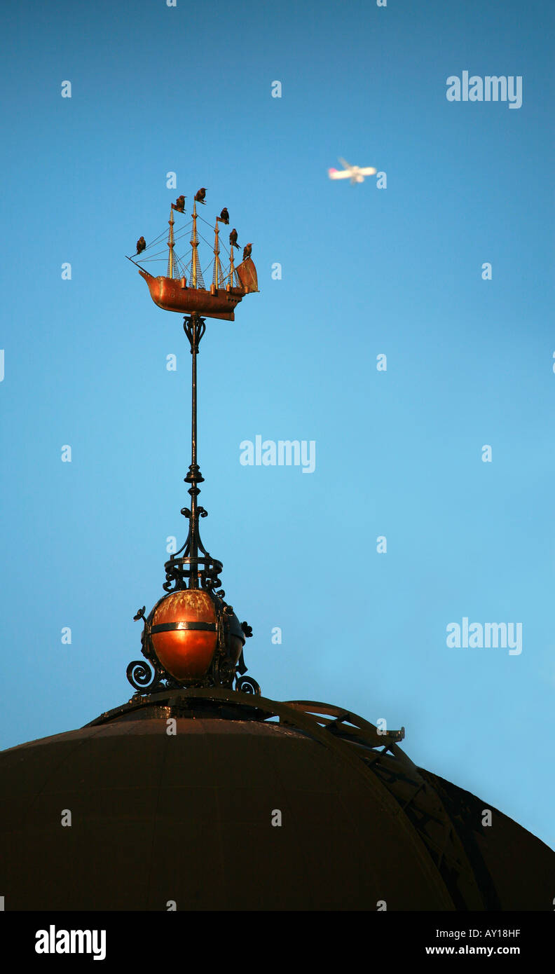 Per gli storni guarda il passaggio di un jet come essi appollaiarsi su montanti di una nave banderuola sulla cupola del nuovo Osservatorio Greenwich Foto Stock