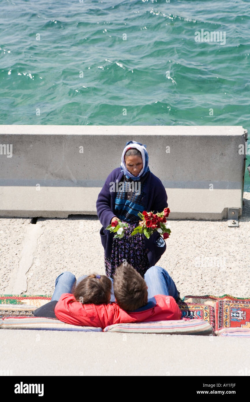 Una donna che vendono fiori per un paio ad Istanbul in Turchia Foto Stock