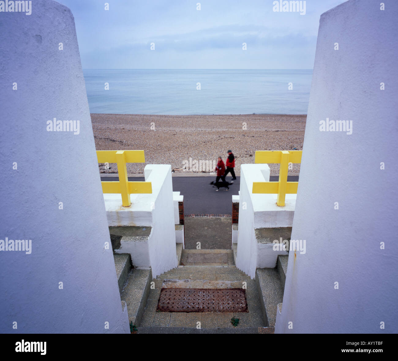 Giovane con il cane a camminare lungo il lungomare a Leas Folkestone Kent England Regno Unito Foto Stock