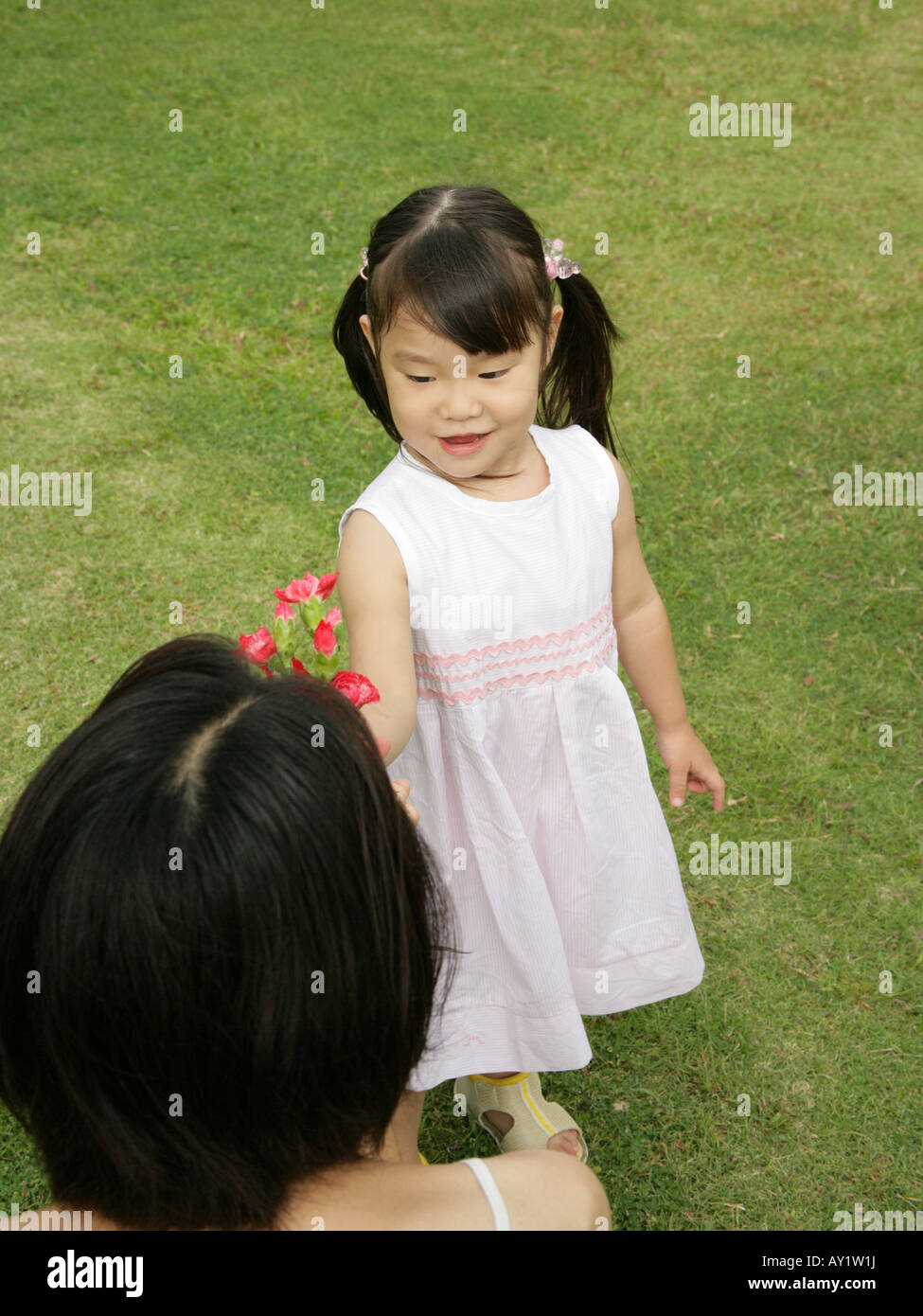 Angolo di alta vista di una ragazza e sua madre holding fiori (Carnation) Foto Stock