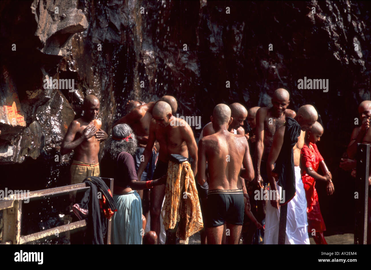 Testa rasata pellegrini di balneazione in cascata venerato nei pressi di Sri Kapileswaraswami tempio, Tirumala hill, Andhra Pradesh, India Foto Stock