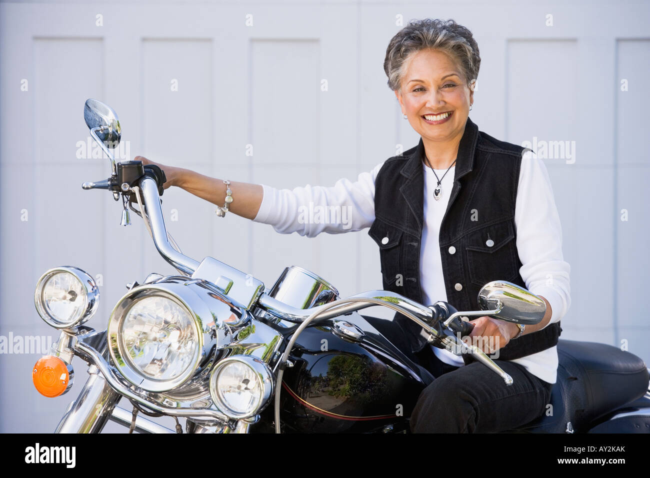 Senior americano africano donna seduta sul motociclo Foto Stock