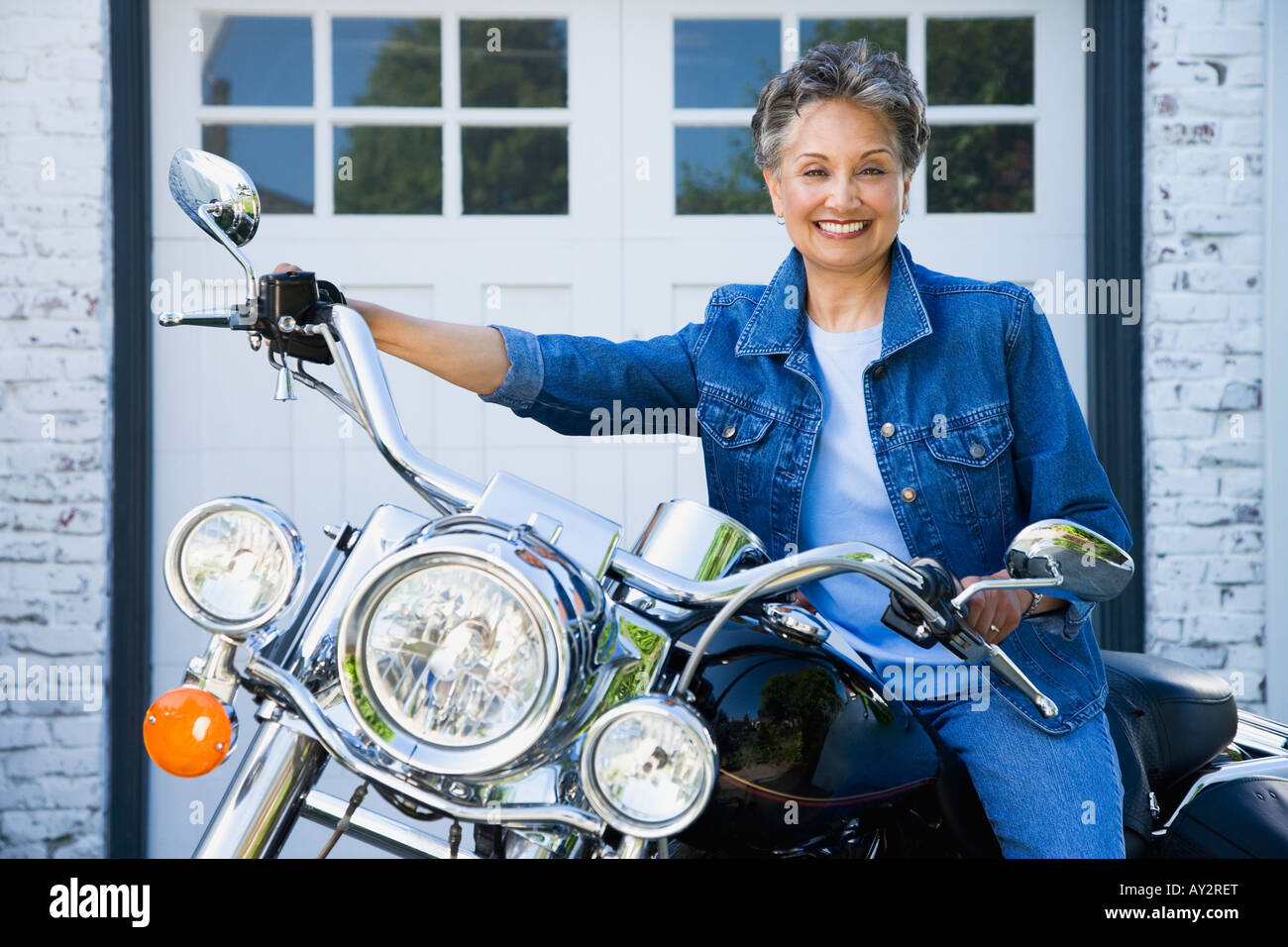 Senior americano africano donna seduta sul motociclo Foto Stock