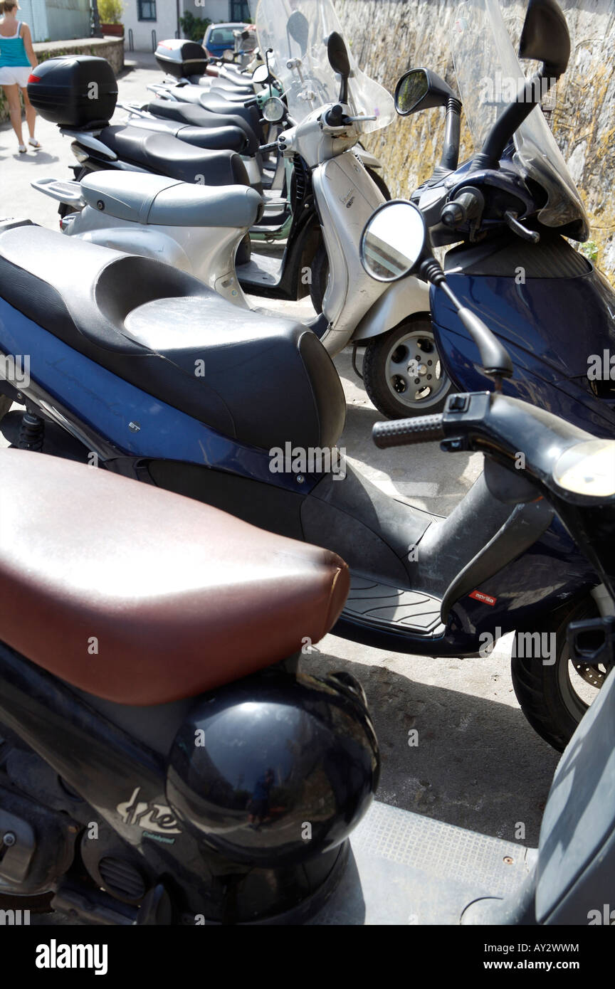 Una linea di Vespa scooter e gli altri ciclomotori su stradine di Sorrento parcheggiata sul lato della strada nel parcheggio designata Foto Stock