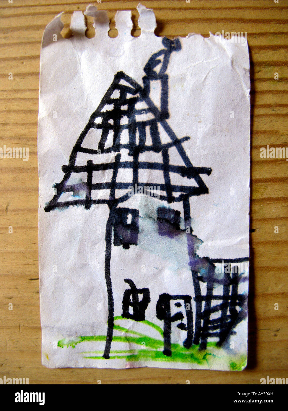 Bambino s il disegno di una casa su un pezzo di carta Foto Stock