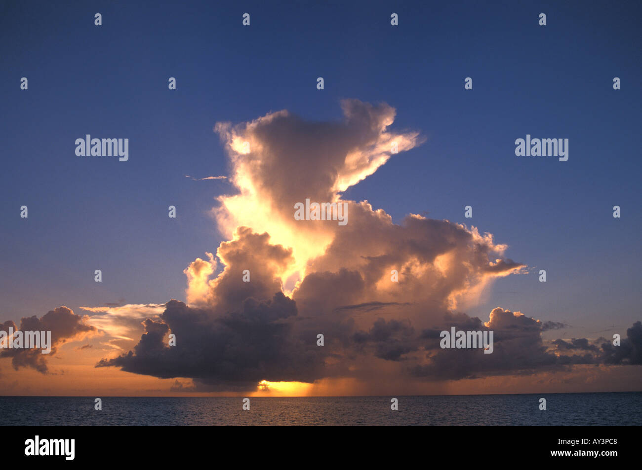 Nuvole pioggia oltre oceano al tramonto Foto Stock