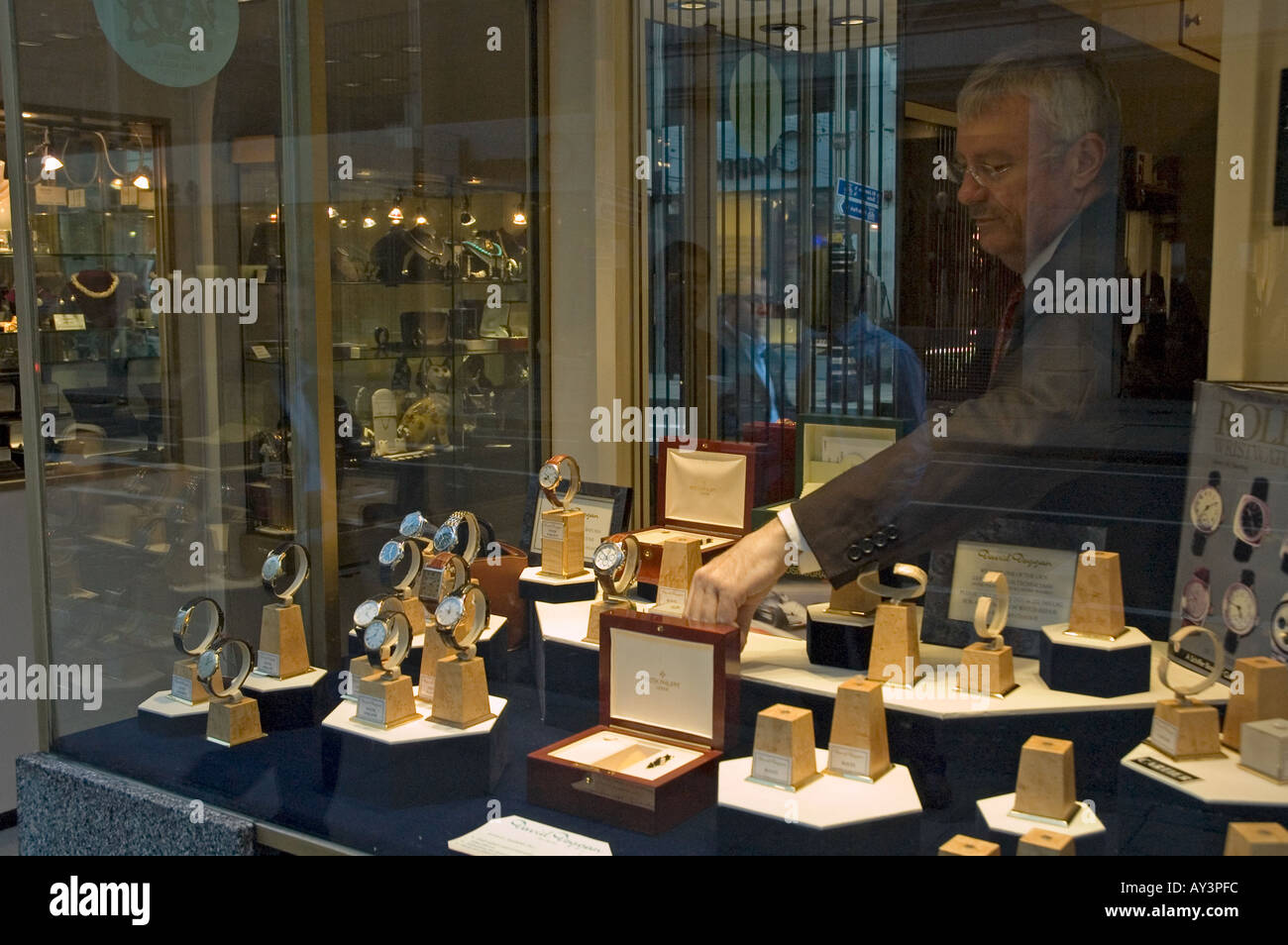Uomo disponendo nuovamente la finestra di visualizzazione in un negozio di orologi Bond Street Londra Foto Stock