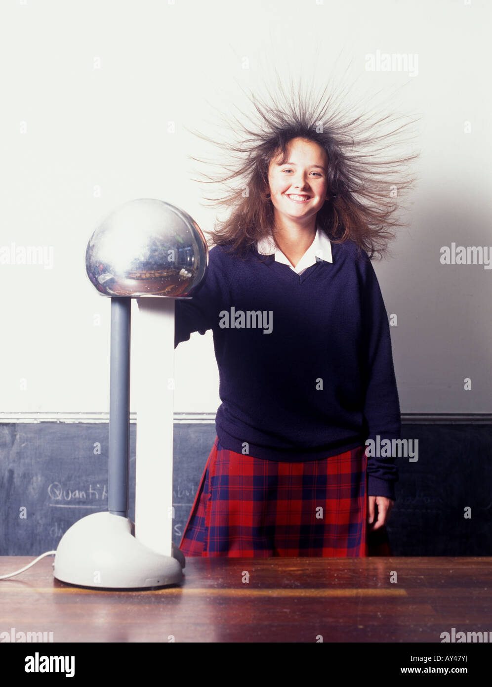 Schoolgirl essendo caricato con elettricità statica rendendo il suo stand capelli su fine Foto Stock