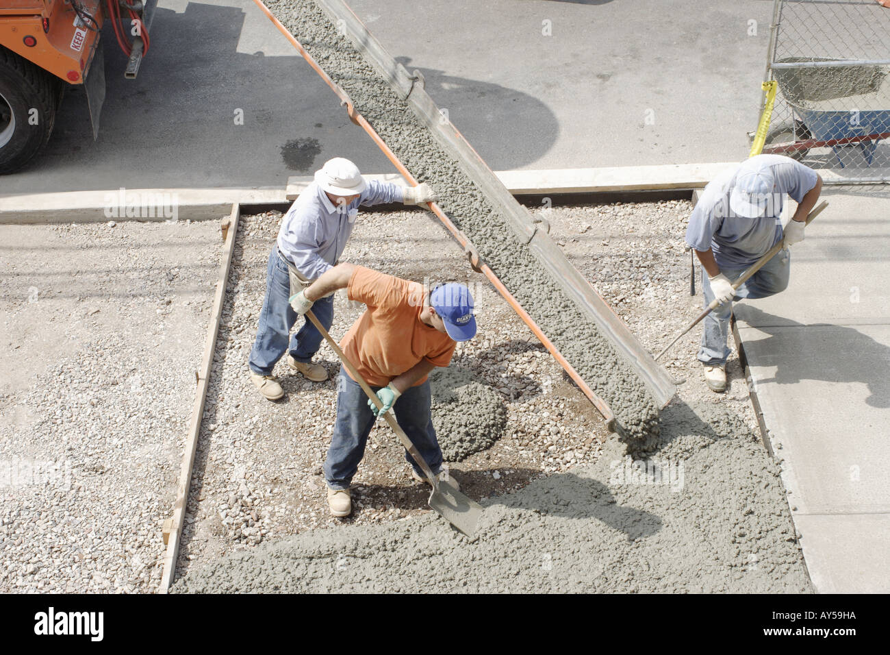 Lavoratori colata di cemento per un marciapiede, Foto Stock