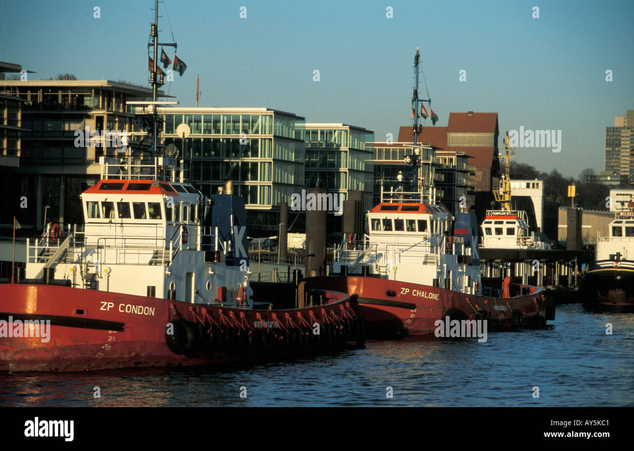 Il rimorchiatore a traino centrale di Neumuehlen nel porto di Amburgo, Germania; in background uffici moderni edifici lungo il fiume Elba Foto Stock