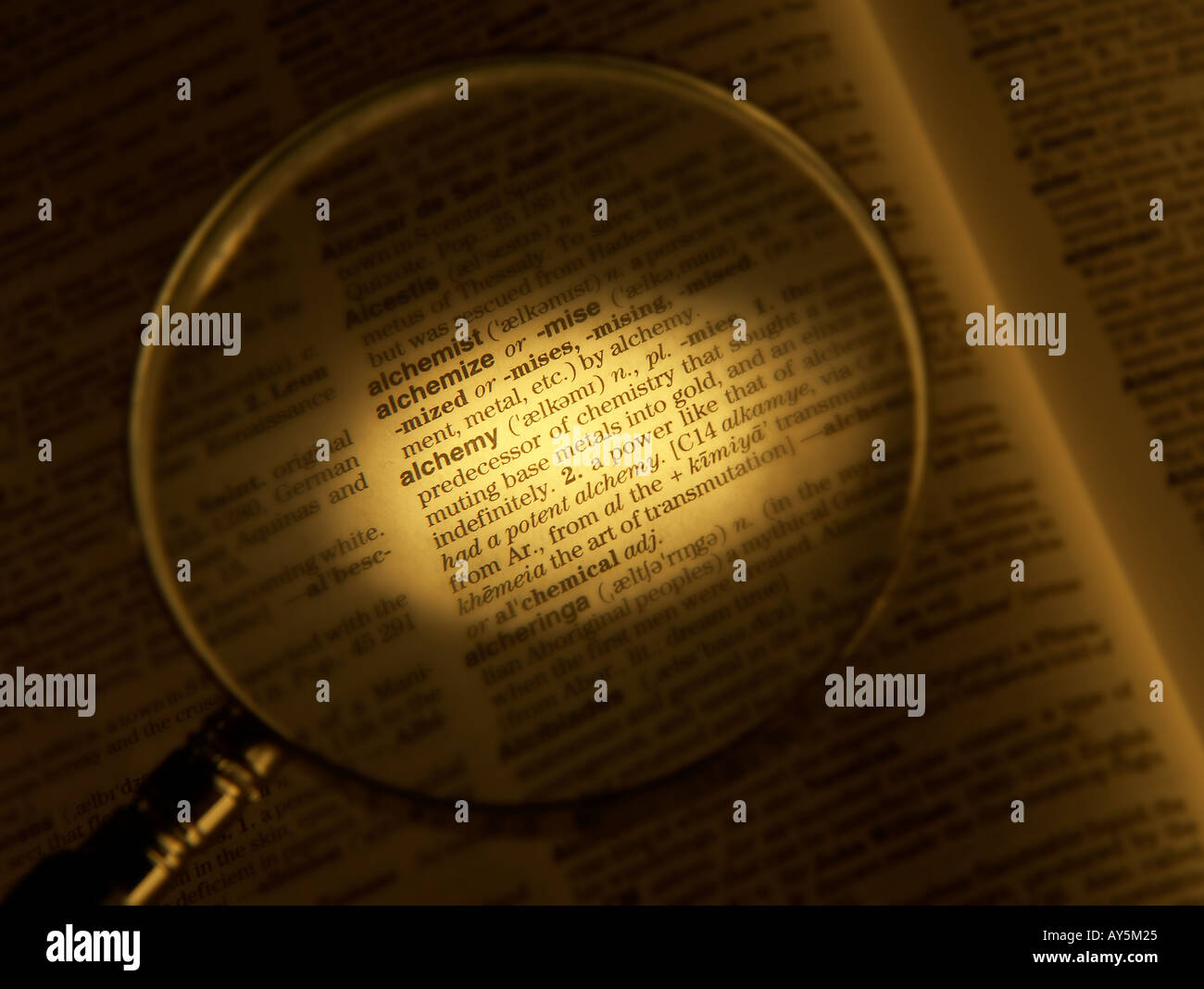 Lente di ingrandimento sul dizionario pagina che mostra la definizione della parola Alchimia Foto Stock