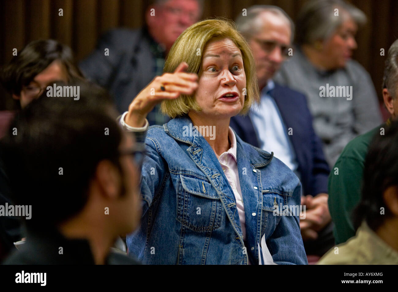 Una donna reagisce negativamente a un altoparlante istruzione alla California riunione politica nota le espressioni del pubblico Foto Stock