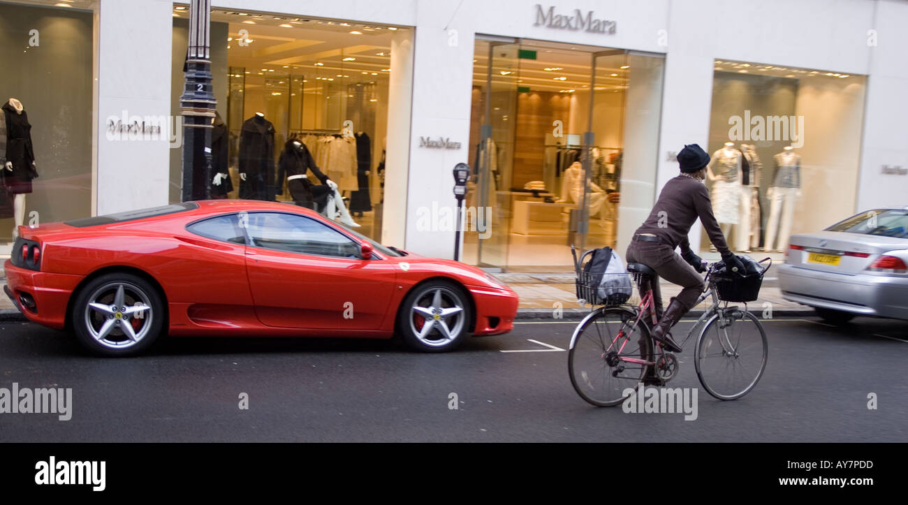 Ciclista passando da una Ferrari New Bond Street London REGNO UNITO Foto Stock