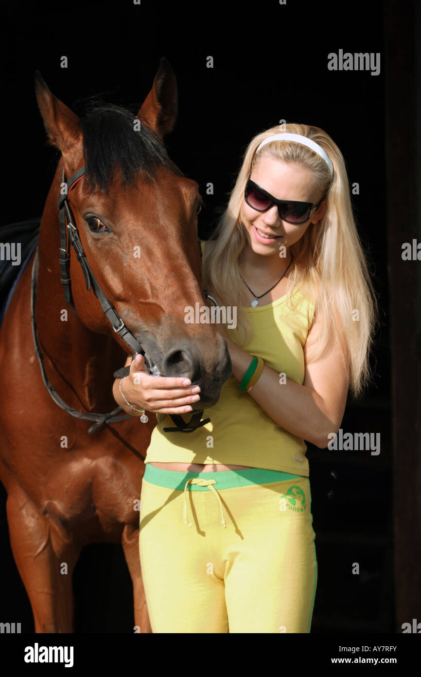 Il cavallo e la ragazza. Bionda. Caucasiche. Europeo. Foto Stock