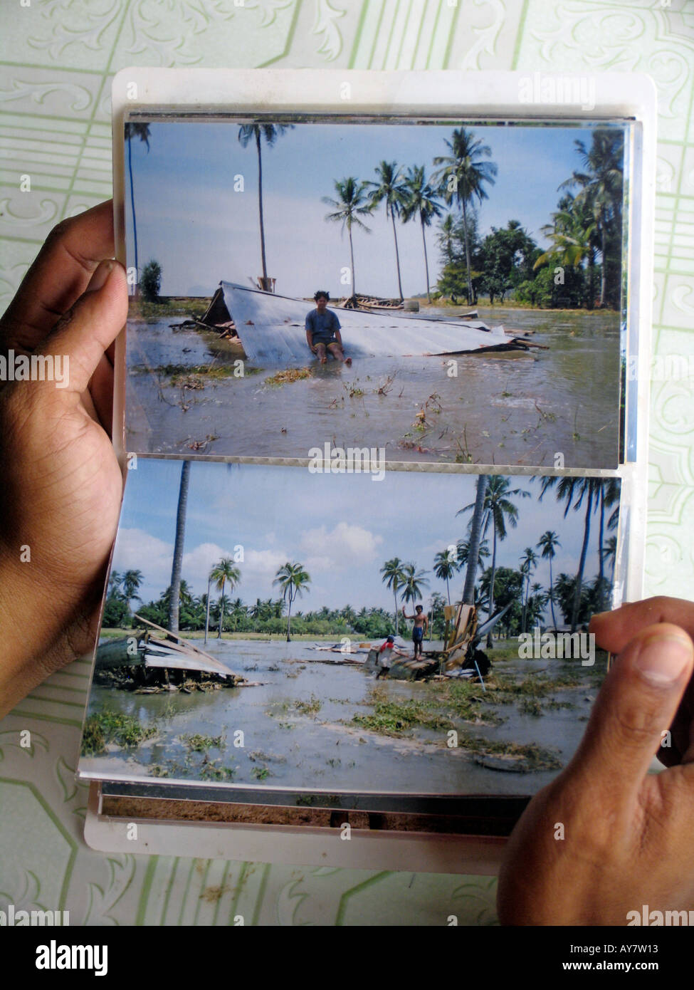 Fisherman mostra le fotografie della sua casa distrutta dal maremoto 2004 Ko Sukorn isola della Thailandia Foto Stock