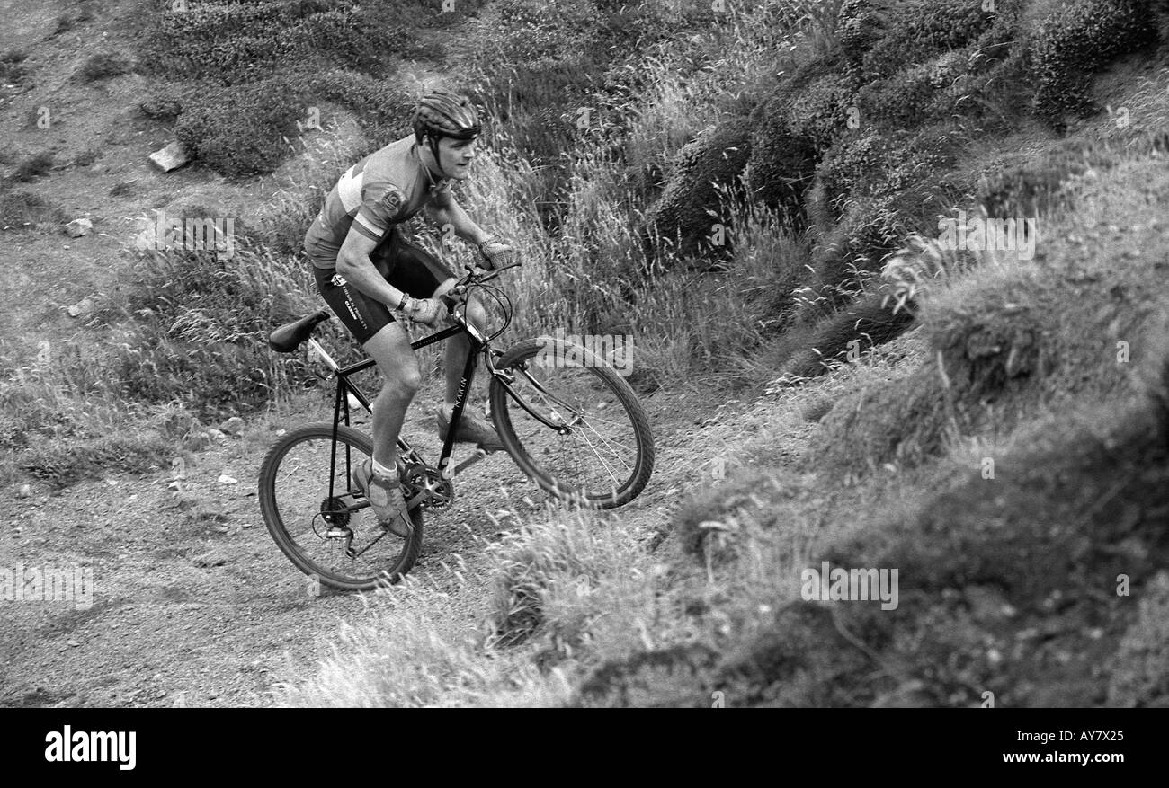 Ciclista professionista della formazione sulla ripida collina su una mountain bike. Foto Stock