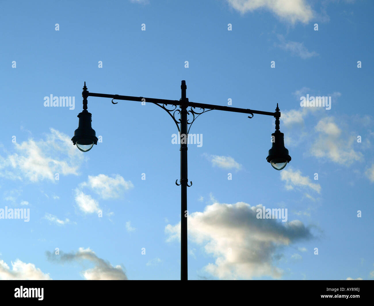 Via la luce siloutted contro un cielo blu con nuvole. Foto Stock