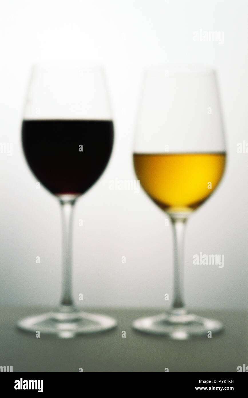 Due bicchieri di vino con vini rossi e bianchi, sfocato Foto Stock