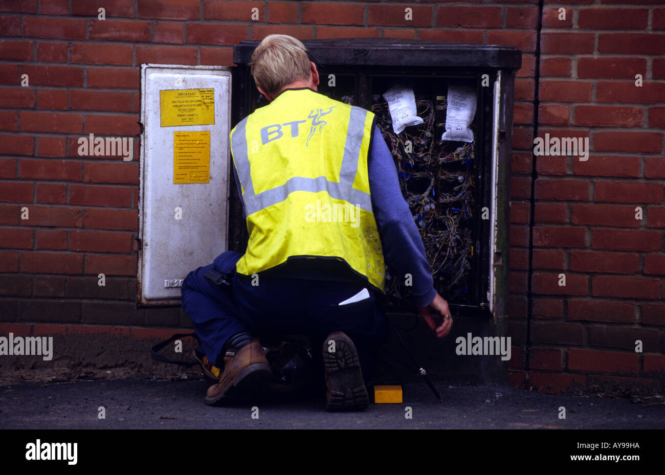 British Telecom engineer lavorando su un telefono cassetta di giunzione nel villaggio di a Alderton, Suffolk, Regno Unito. Foto Stock