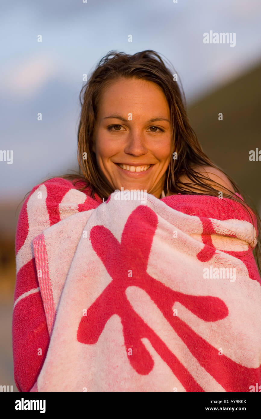 Surfista femmina asciugando i capelli con un asciugamano, Cornwall, Regno Unito Foto Stock