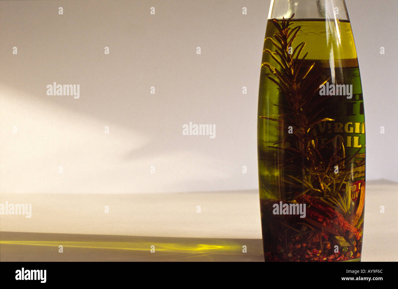 Un albero di luce naturale attraverso un pieno di erbe olio vergine di oliva Bottiglia Foto Stock