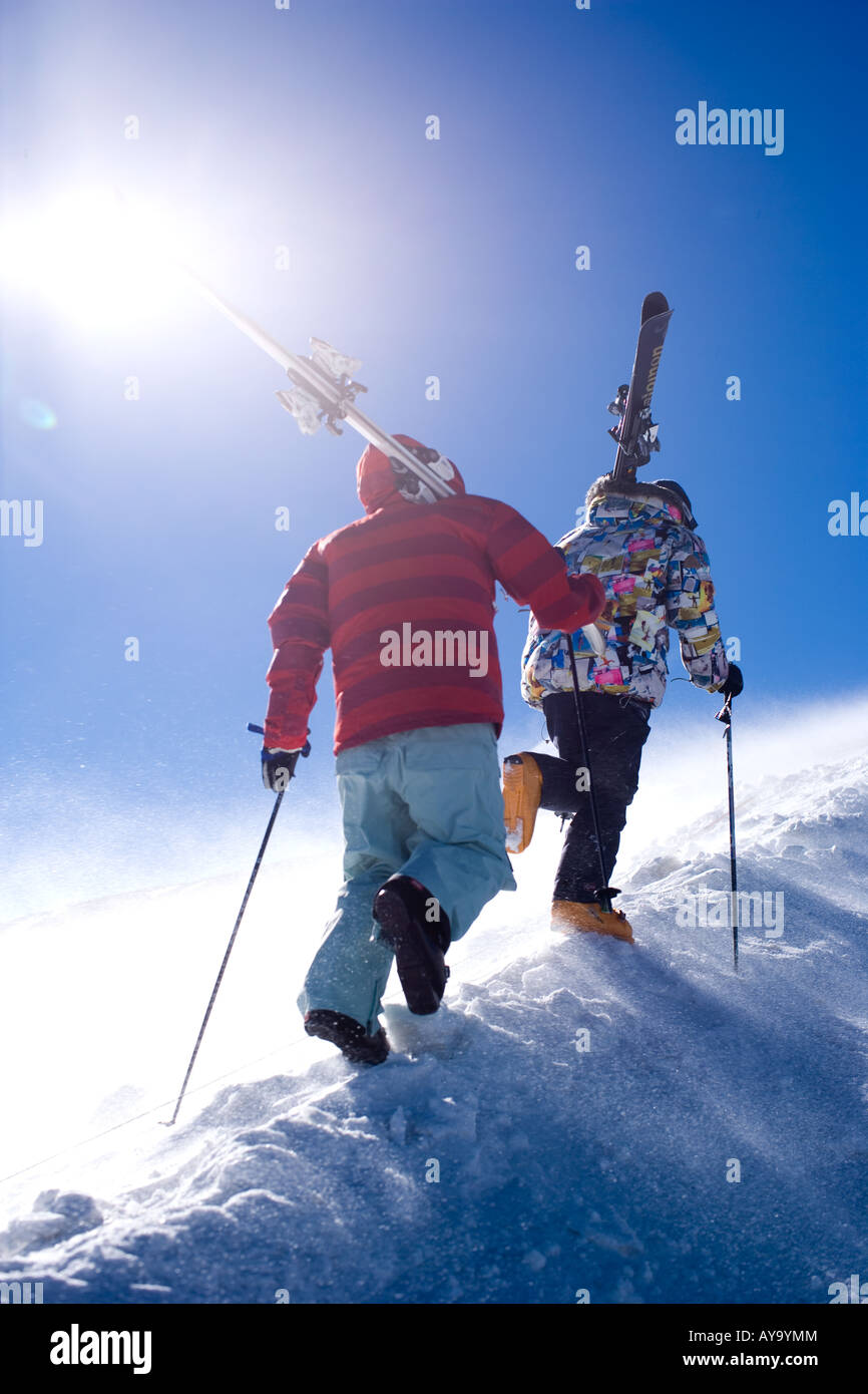 Gli sciatori il trasporto di attrezzature su ripido versante della montagna, Tignes, Francia Foto Stock