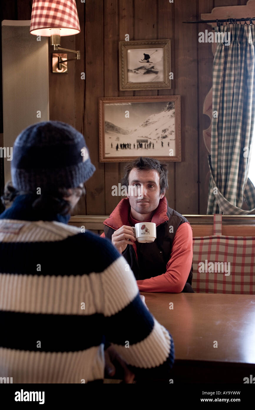 Gli amici siedono parlando a tavola in apres ski bar, Tignes, Francia Foto Stock