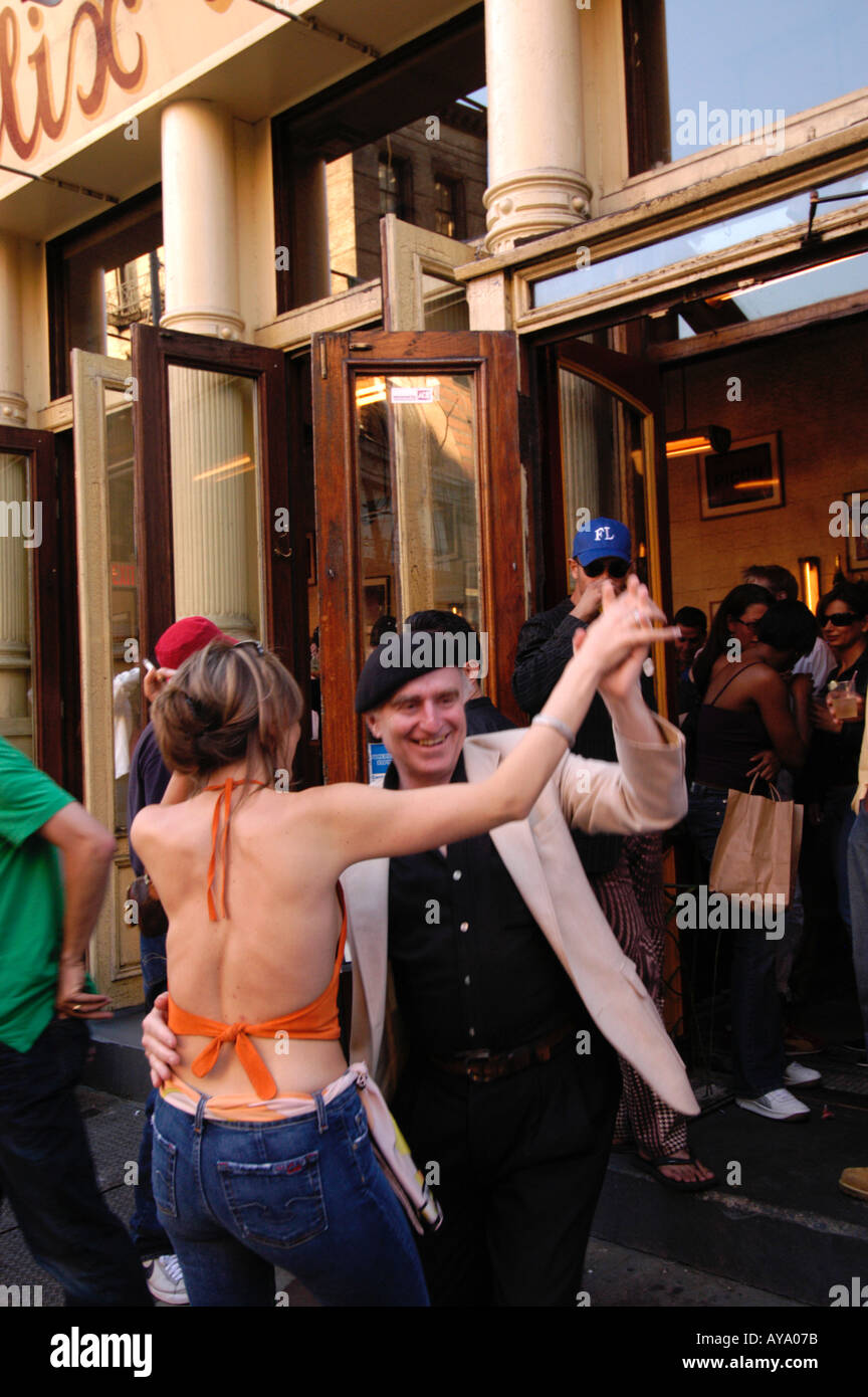 L uomo e la donna ballare al di fuori del bar alla moda di Soho di New York City Foto Stock