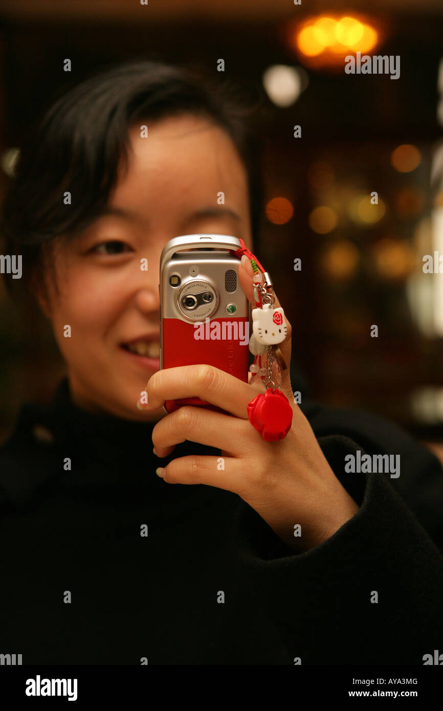Giovane donna cinese photographes con mobile Foto Stock