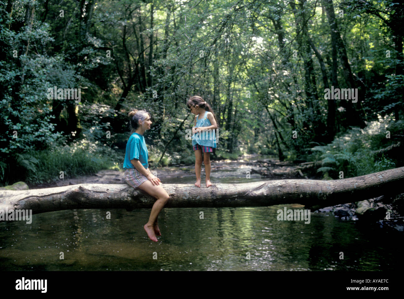 Madre e figlia seduta sul fiume ad albero Brecon Beacons Powys Wales UK SB Foto Stock