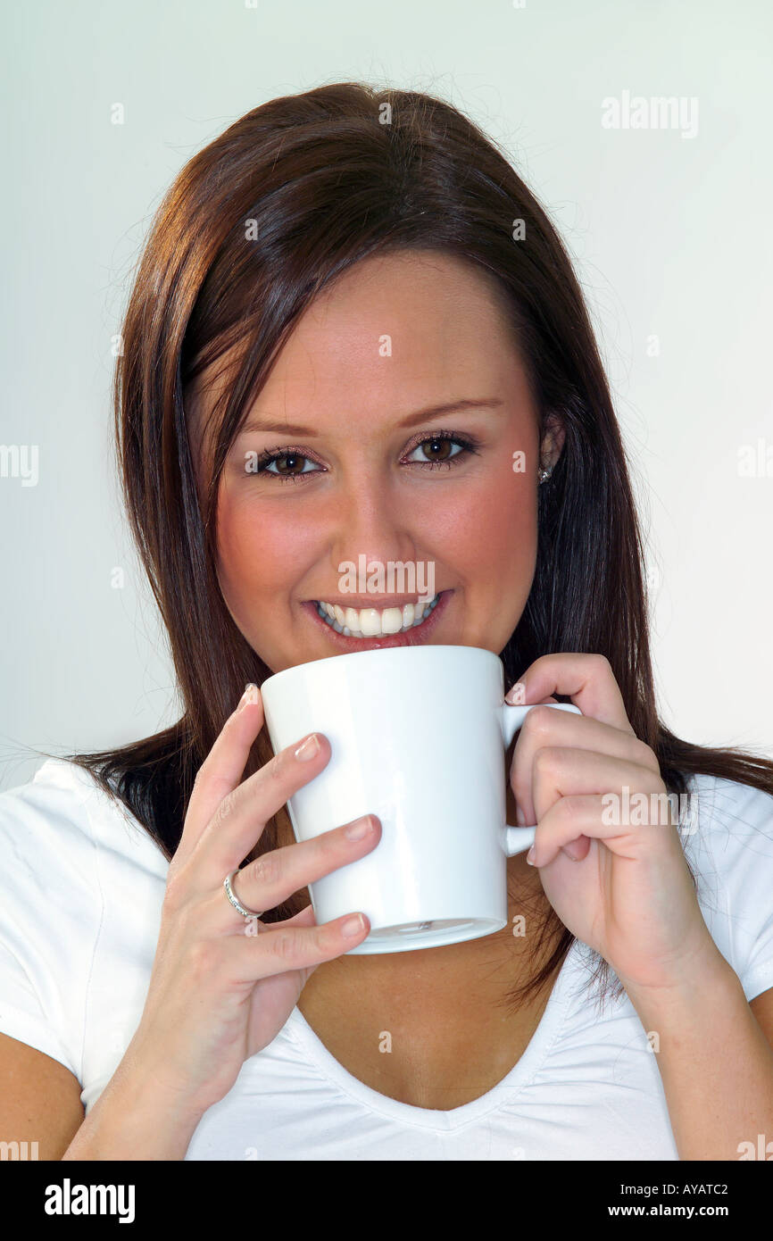 Ritratto di giovane donna di bere dalla tazza da caffè Foto Stock