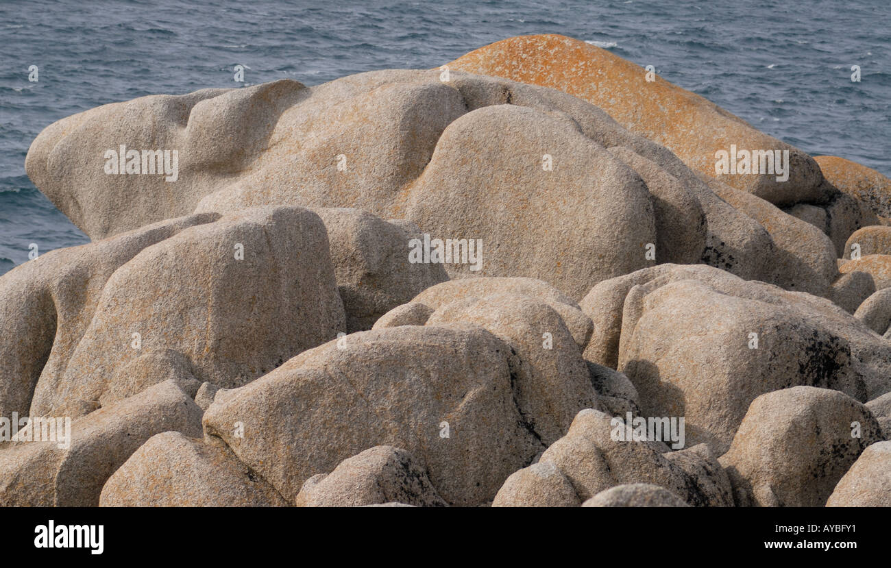 Lichin coperta di rocce di granito a testa Peninnis dove le scogliere sono state erose in forme arrotondate dal vento e mare Foto Stock