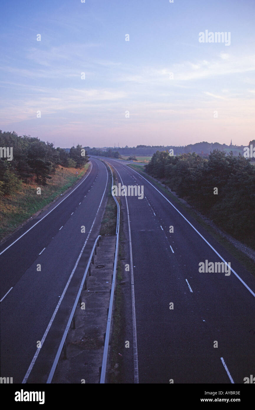 La strada a doppia carreggiata senza traffico al crepuscolo Foto Stock