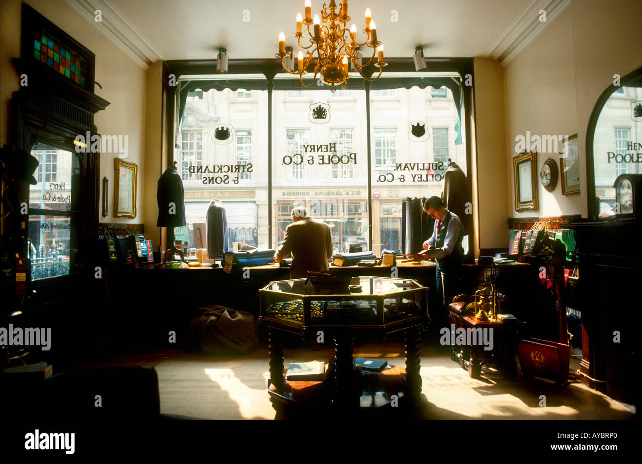 Maestri Sarti lavora nel soleggiato shop interno della showroom di antiquariato di Henry Poole & Co, Savile Row, Mayfair, Londra Foto Stock