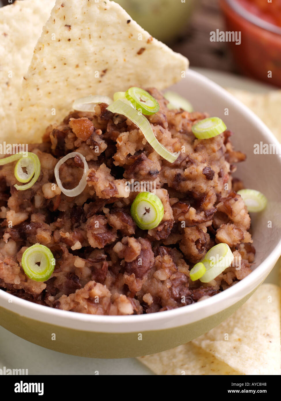 Close up di una ciotola di refried fagioli con tacos Foto Stock