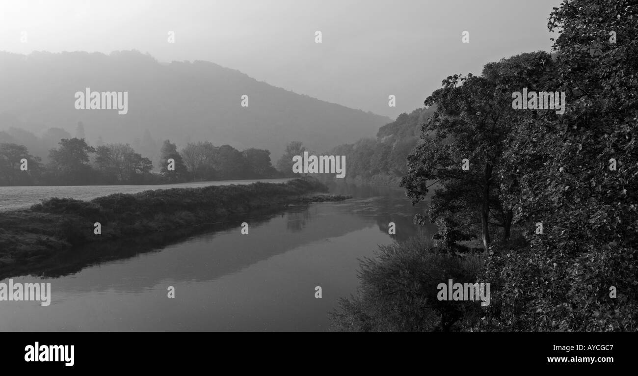 Splendido e tranquillo fiume che scorre attraverso la campagna di autunno nei primi giorni di sole di mattina e la nebbia Foto Stock