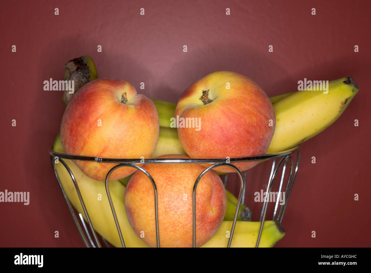 Cestello in filo metallico della frutta con le nettarine e le banane Foto Stock