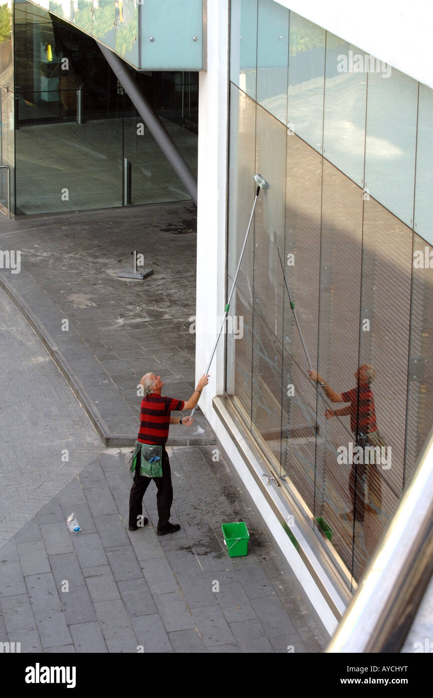 Un detergente per vetri lavorando su locali commerciali a Birmingham in Inghilterra Foto Stock