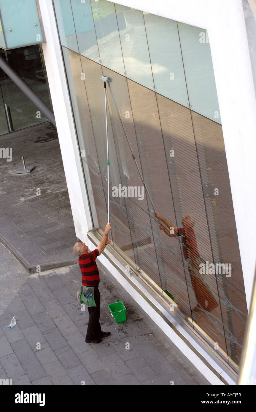 Un detergente per vetri lavorando su locali commerciali a Birmingham in Inghilterra Foto Stock